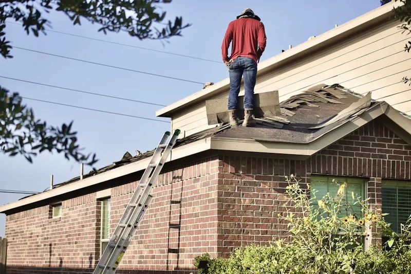 Professional roofer working on a residential roof in Claysburg
